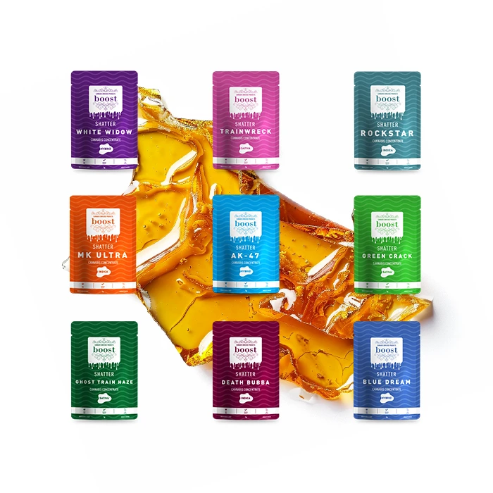 A variety of colorful Boost Shatter cannabis concentrate packaging displayed over a golden cannabis concentrate backdrop. Featured strains include White Widow, Trainwreck, Rockstar, MK Ultra, AK-47, Green Crack, Ghost Train Haze, Death Bubba, and Blue Dream.