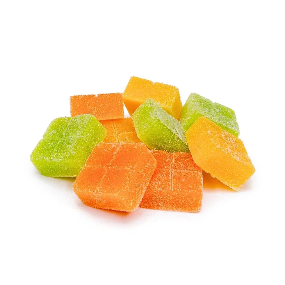 A close-up of orange and green cannabis-infused gummies, stacked together showing their sugar-coated surface