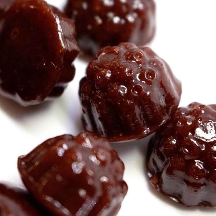 Close-up of Dames Gummy Co. gummies from Weed Market, featuring dark berry-shaped mushroom edibles with a glossy finish