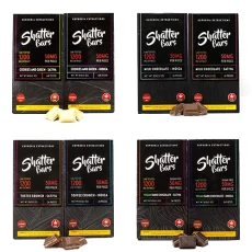 A set of four Shatter Bars 1200mg THC chocolate bars displayed in various flavors: Cookies and Green (Sativa and Indica), Milk Chocolate (Sativa and Indica), Toffee Crunch (Sativa and Indica), and Vegan Dark Chocolate (Sativa and Indica). The bars are showcased with their corresponding chocolate pieces.