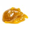 A close-up image of the sticky, yellow-orange live resin concentrate, showcasing its rich texture and terpene-rich composition for potent cannabis consumption.