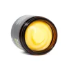 A close-up of MOTA Green Balm 2oz, displaying the smooth yellow ointment inside the jar, emphasizing its creamy and soothing texture