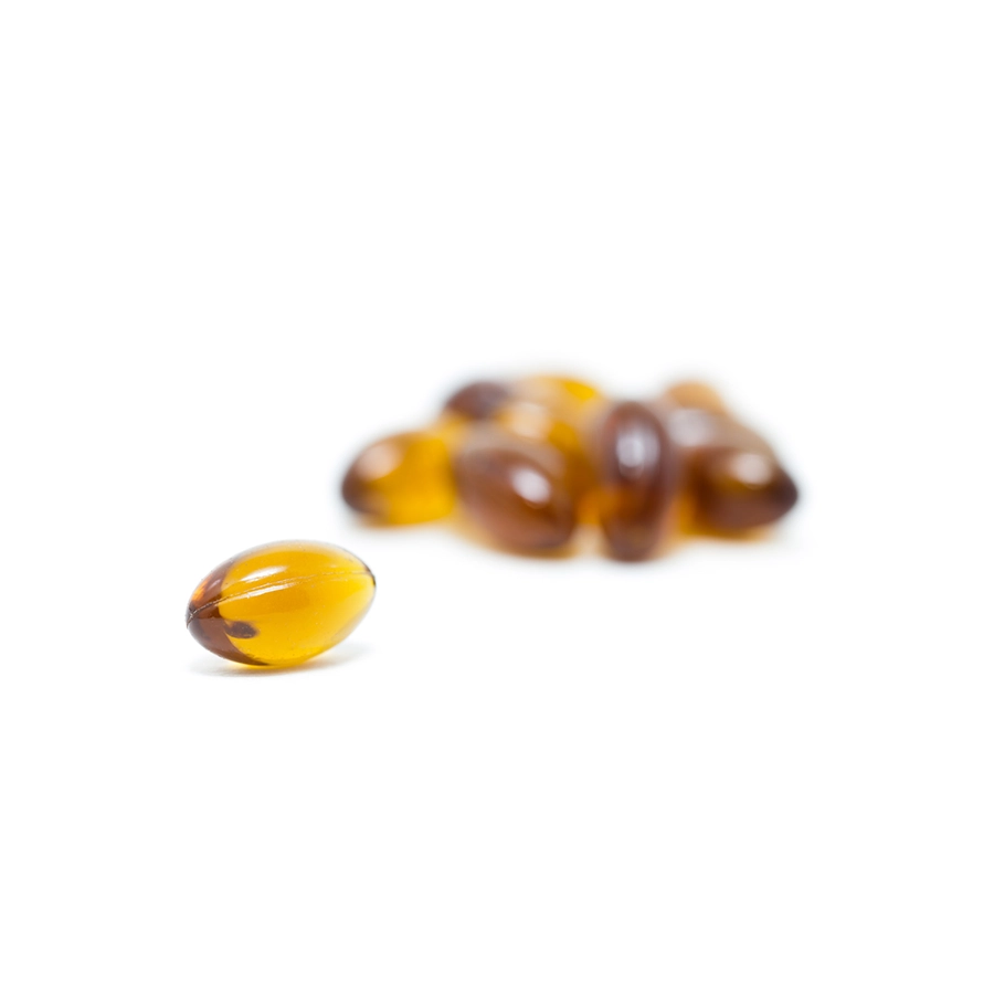 Close-up of MOTA Sleep Capsules in softgel form, highlighting the golden color of the capsules