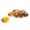 Close-up of a single amber-colored MOTA THC capsule, containing 100mg of THC