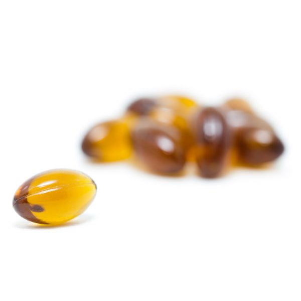 Close-up of a single amber-colored MOTA THC capsule, containing 100mg of THC