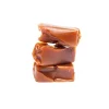 A close-up of three rich, creamy caramel pieces stacked on top of each other, showcasing the smooth texture of Twisted Extracts Caramelts