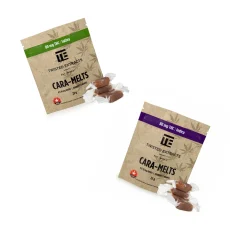 Twisted Extracts Cara-Melts packaging for both Indica and Sativa varieties, each containing 80mg THC. The Indica package has a purple banner, while the Sativa package features a green banner. Both packages are displayed in brown kraft paper bags with unwrapped caramel pieces placed beside them
