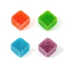 Close-up of four colorful Twisted Extracts Twisted Singles gummies, featuring red, green, blue, and purple cubes coated in sugar