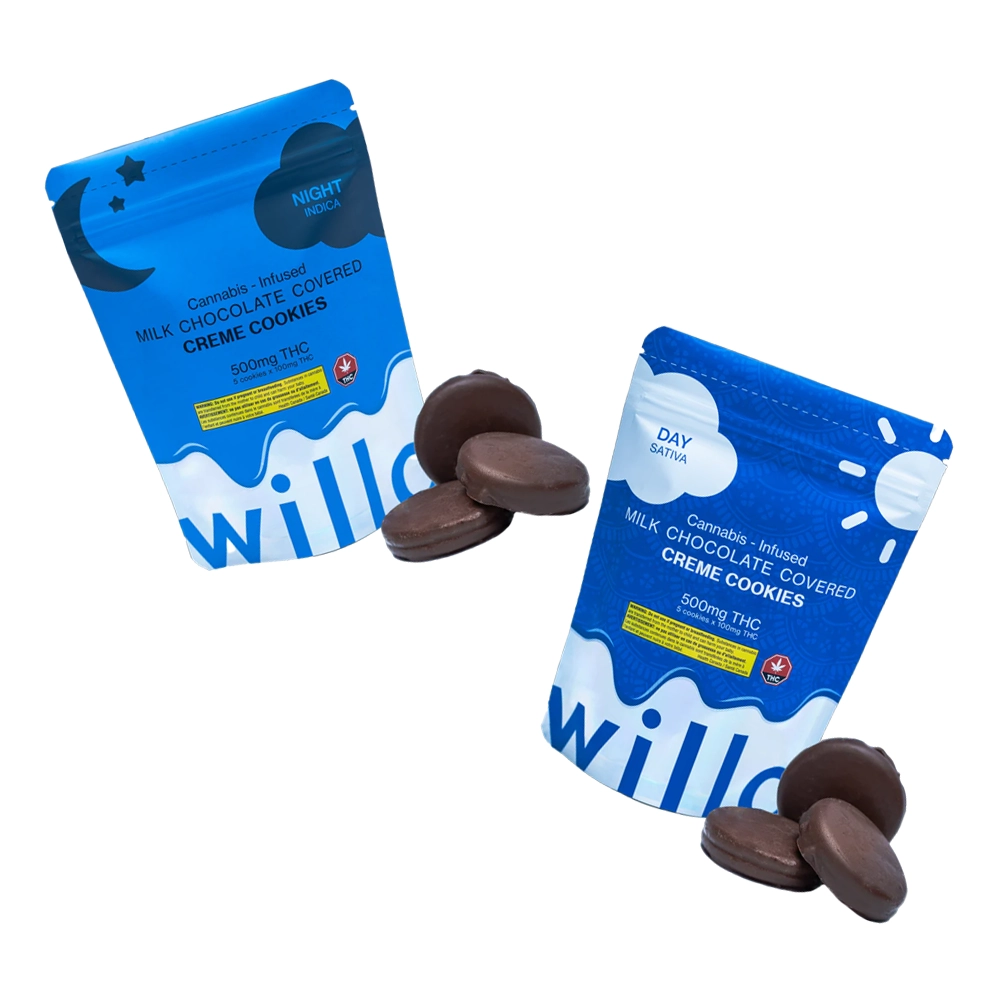 Two blue bags of Willo cannabis-infused milk chocolate-covered creme cookies, one labeled for nighttime (indica) with a crescent moon and stars design, and the other labeled for daytime (sativa) with a sun design. Each bag is accompanied by three chocolate-covered cookies displayed beside it.