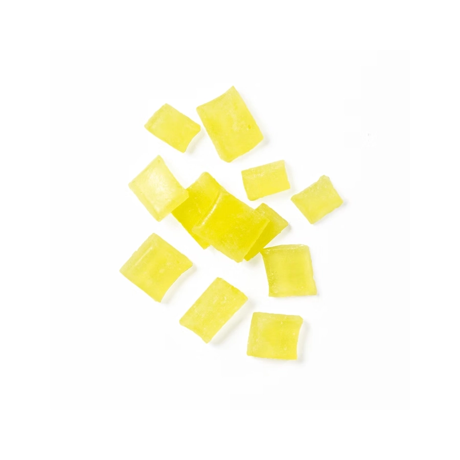 Lemon hard candy pieces in vibrant yellow scattered on a white background.