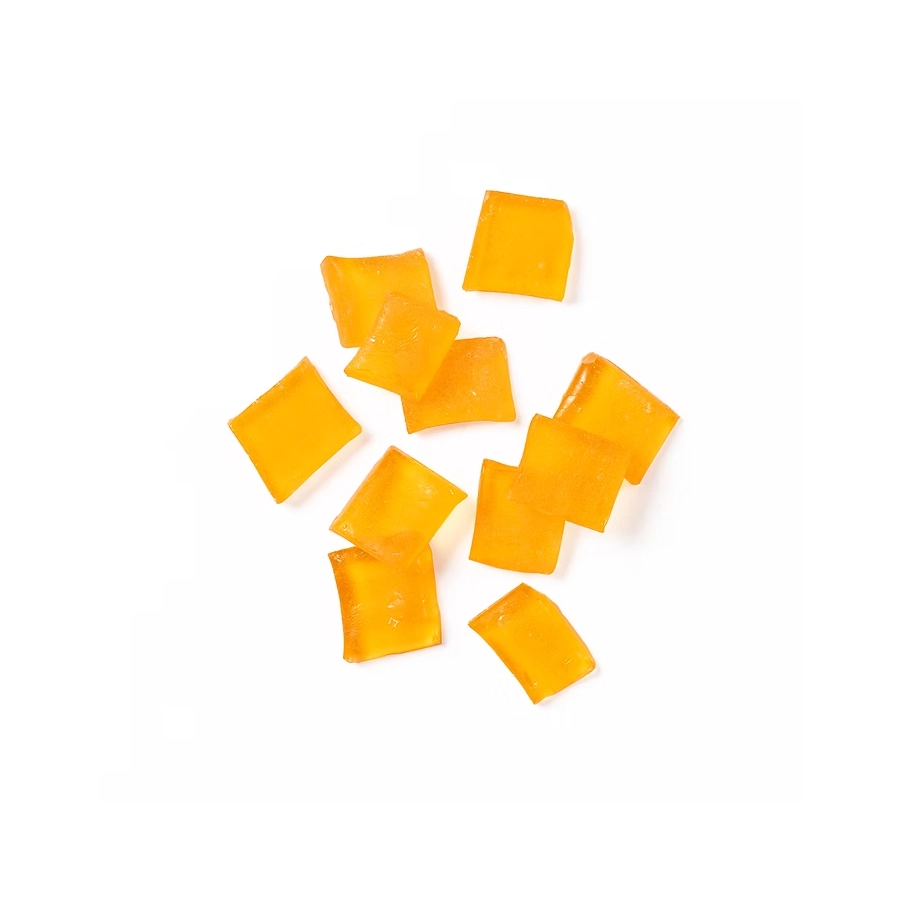 Orange hard candy pieces in a translucent golden hue on a white background