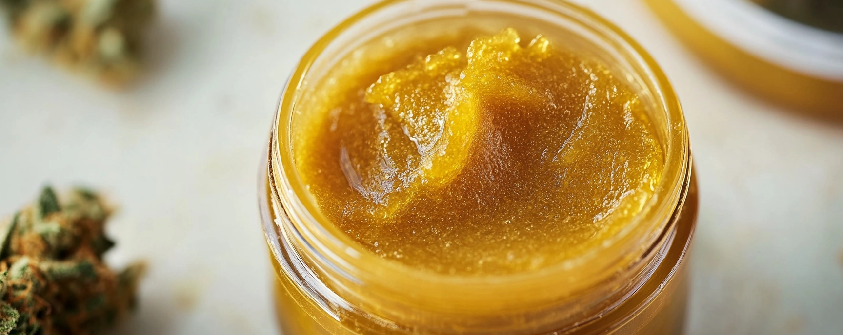 Glass jar filled with creamy golden cannabis budder concentrate, ideal for those looking to buy budder at Weed Market