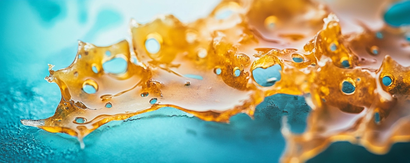 Golden cannabis shatter concentrate on blue surface – buy cheap shatter online in Canada at Weed Market