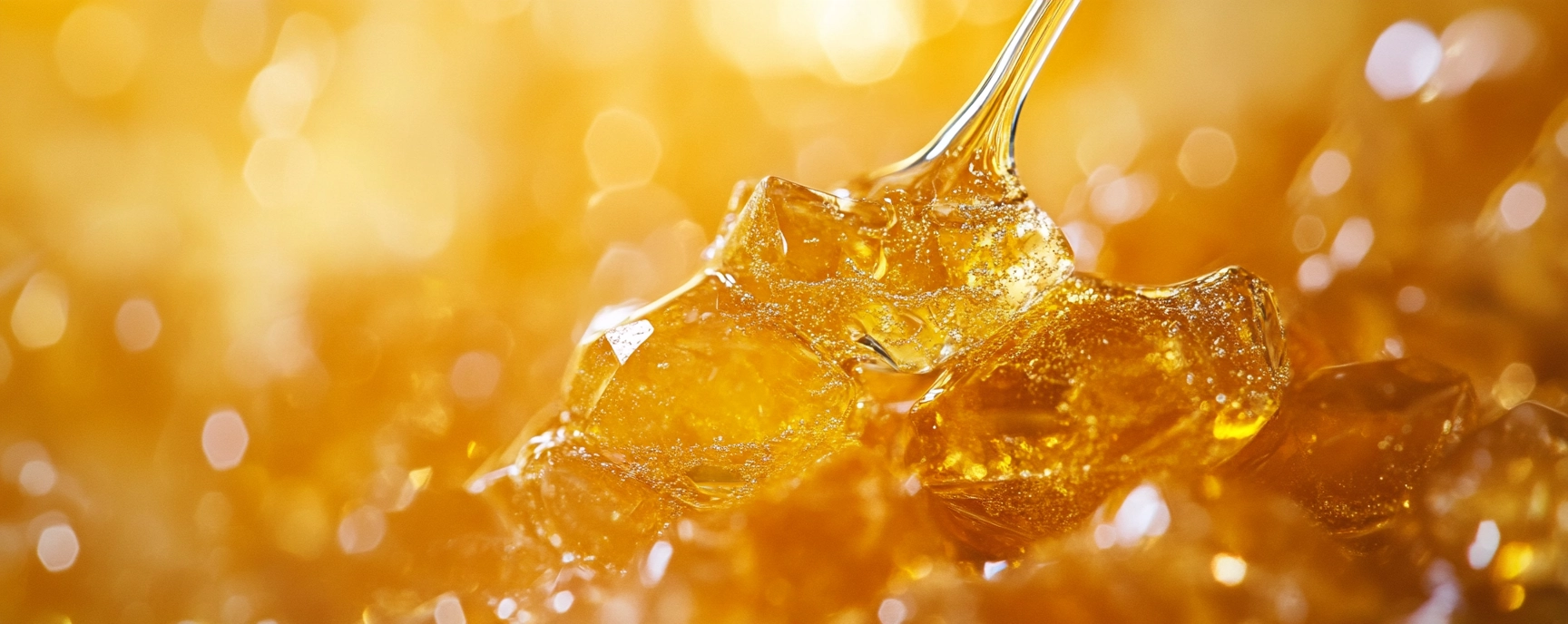 Pile of glistening THC diamonds on a golden background with terpene-rich texture, emphasizing purity and potency.
