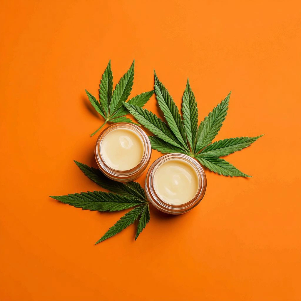Cannabis skincare cream jars with leaves on orange background
