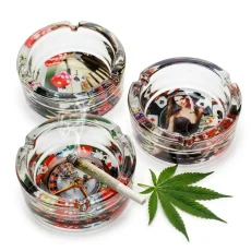 Casino Glitter Glass Ashtray with dice, cards and roulette designs, lit cannabis joint resting on one ashtray