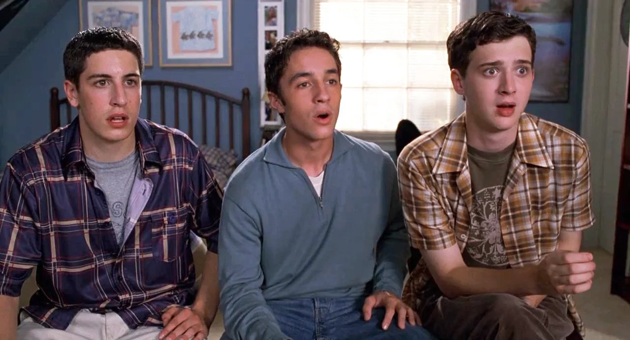 Jim, Kevin and Finch sit on a bed looking shocked in a scene from American Pie